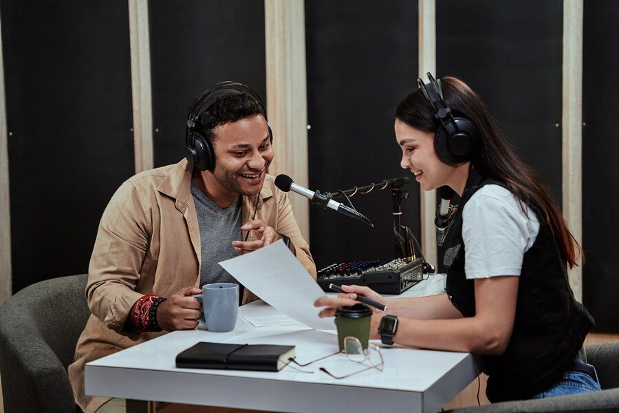 portait-two-radio-hosts-man-woman-talking-with-each-other-reading-script-while-getting_386185-1199